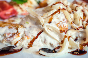 Obraz na płótnie Canvas A fish dish. Fried cod in onion sauce.