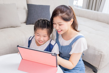 Mom and daughter use tablet happily