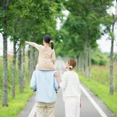一本道で肩車をする親子の後姿