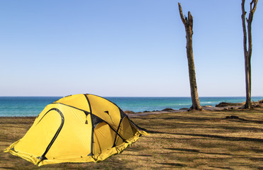 camping am Meer, gelbes Zelt an der Küste