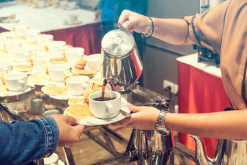 Blurred for Background.The waitress filed a glass of white coffee with the hamburger between the brake and the brake food background.