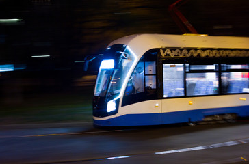 Fototapeta na wymiar The tram rushes along the rails at high speed Photo taken from the roadside ,Moscow, spring 2019, sky, tram, road 