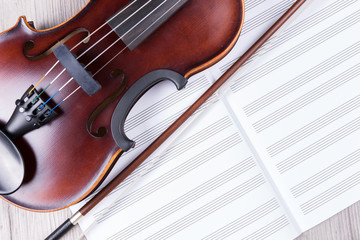 Naklejka premium Classical violin with empty music sheet book. Studio shot of old violin. Classical musical instrument