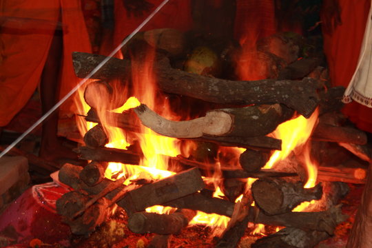 Bhadrak, Odisha, India. 13th April, 2019.Homa is concluded with a Purnahuti, Aarthi and offering the Thamboolam and cuconuts to Lord Agni. Priests continue with the last of the mantras. motion blur