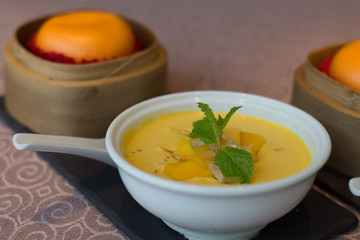 Chilled Mango Puree with Pomelo bits and mint leaves and served with Golden Custard Bun
