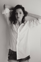 Fototapeta premium young girl in white shirt standing next to white wall