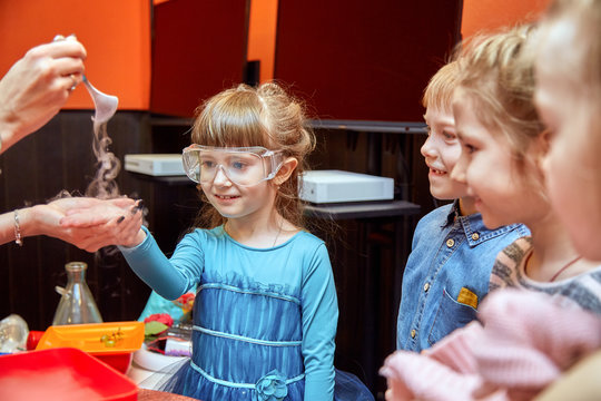 Chemical show for kids. Professor carried out chemical experiments with liquid nitrogen on Birthday little girl.
