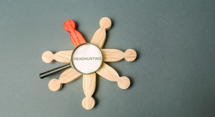 A magnifying glass with the word Headhunting and a crowd of people. The concept of hiring people to work. Staff recruitment. Search for employees. Headhunter services. Hiring. Hire. HR.