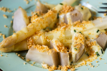 Boiled asparagus and topinambur with breadcrums and sauce.