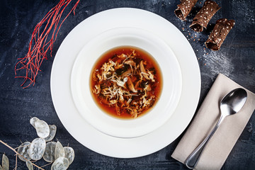 Top view on crab soup served in white plate on dark background. Flat lay food for lunch. Seafood. Reaydy for eat. Picture for recipe. Copy space for design. View from above