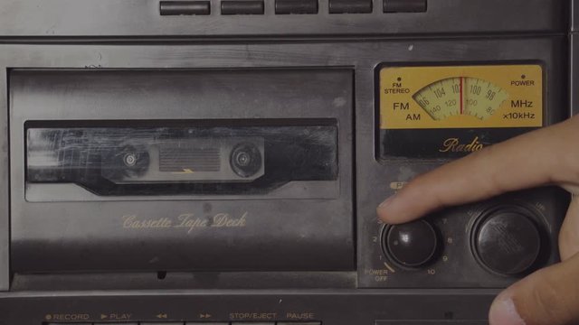 turning up the volume of and old retro cassette radio player