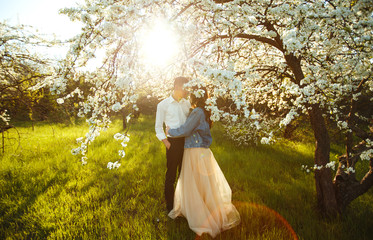Beautiful loving couple in the blooming gardens. Wedding concept. Great sunset light. Lovely newlyweds.