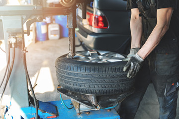 car mechanic changing tire on the rim in service garage