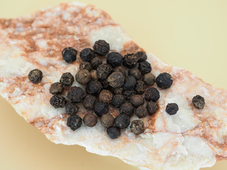 black peppercorns on a marble stone