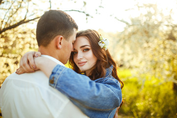Fototapeta premium Beautiful loving couple in the blooming gardens. Wedding concept. Great sunset light. Lovely newlyweds.