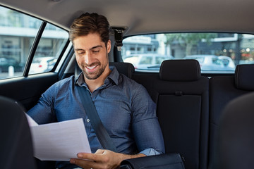 Fototapeta na wymiar Businessman reading documents in car