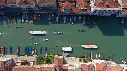 Aerial drone top view photo of iconic and unique colourful Gondolas in small Canal near Rialto bridge, Venice, Italy