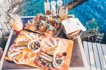 Tasty italian snack. Fresh bruschettes, cheeses and meat on the board in outdoor cafe with amazing view in Manarola
