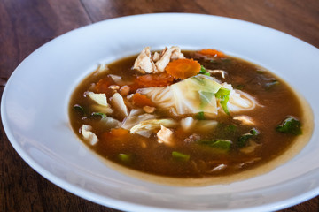 Mixed tofu and chicken in oyster soup in white plate.