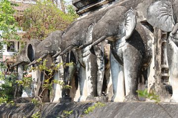 Fototapeta na wymiar statues of elephants on a stupa in a buddhist temple (wat chiang man) in chiang mai (thailand)