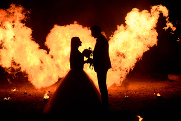 Fototapeta premium Wedding couple with skull face art is standing in the dark