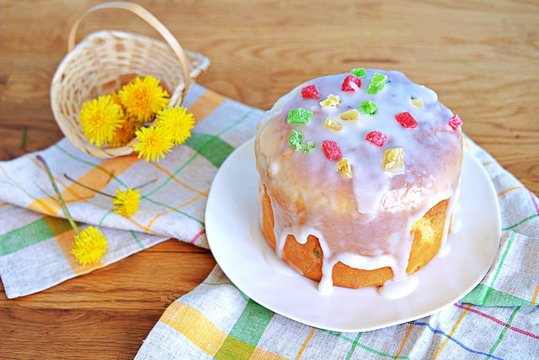 Traditional Easter cake on a white plate, decorated with icing sugar and candied fruits. Happy Easter.