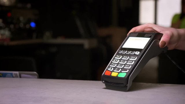Close-up shot of man applies his cellphone to terminal performing successful contactless payment.