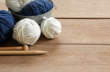 close up of yarn and knitting needles on wooden table in vintage tone, copy space. hobby and leisure concept.