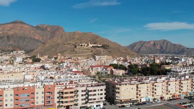 Flight over Orihuela with the drone in the sunshine and blue sky overlooking the monastery on the mountain.