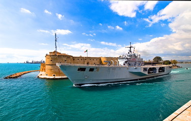 Naklejka premium Taranto, Italy - April 06, 2019: the navigable canal, opening of the bridge and the passage of the Italian navy ship San Giorgio in the navigable channel