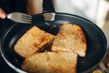Chef toasting whole wheat bread in a pan with butter