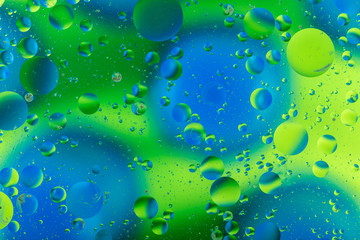 oily drops  in water with colorful background, close-up 