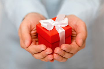 Small red present box in hands