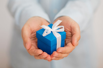 Small blue present box in hands