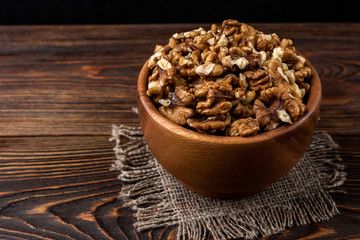 Walnut on dark wooden background.