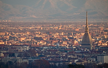 Fototapeta na wymiar Panorama of Turin at sunrise, overlooking the city center and the Mole Antonelliana, a backdrop of snow-capped mountains illuminated by pink light of the rising sun