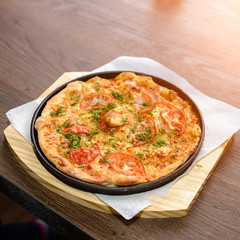 fast food, italian kitchen and eating concept - close up of homemade pizza on wooden table