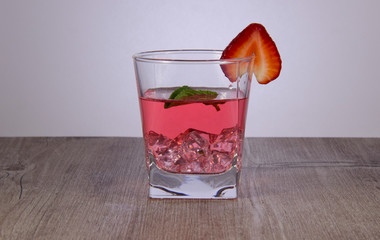 A refreshing drink of strawberry juice with a mint leaf.  Were added to the drink ice.
