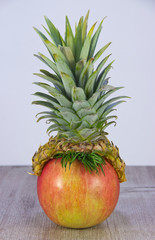 Pineapple hat on apple. It's the basis for drawing a funny human face.