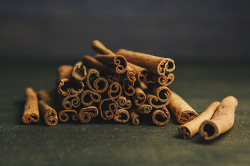 a bunch of whole sticks of fragrant cinnamon on a wooden rural table. copyspace. composition of seasoning and slide flavoring aromatic spice. close-up. front view