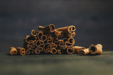 a bunch of whole sticks of fragrant cinnamon on a wooden rural table. copyspace. composition of seasoning and slide flavoring aromatic spice. close-up. front view