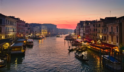 Venice, Italy - December 29, 2018: Sunset view from Ponte Di Rialto on the Grand Canal, with boats and gondolas