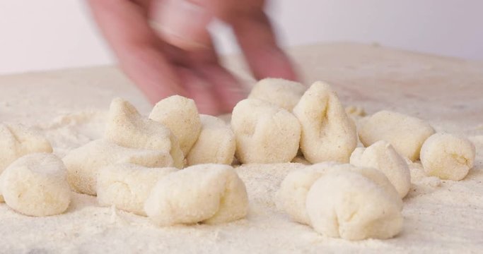 Gnocchi tradizionali di patate, uova e farina, fatti in casa su un tagliere di legno.