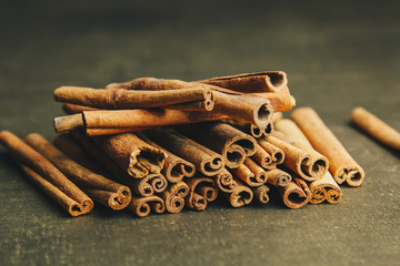 a bunch of whole sticks of fragrant cinnamon on a wooden rural table. copyspace. composition of seasoning and slide flavoring aromatic spice. close-up. top view