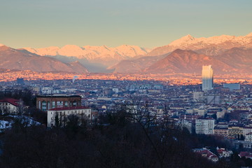 Aerial view of Turin, Italy, at sunrise, with the city center and the Mole Antonelliana, sun is giving its first light on the city