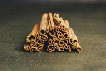 a bunch of whole sticks of fragrant cinnamon on a wooden rural table. copyspace. composition of seasoning and slide flavoring aromatic spice. close-up. top view