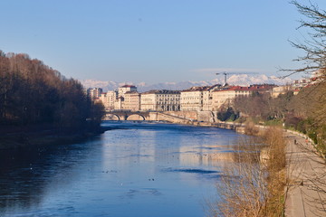 Fototapeta premium Po riverside in a bright spring morning with a blue sky, bridges and reflections on the water surface, Turin, Piedmont, Italy