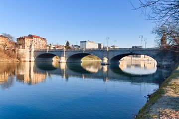 Naklejka premium Po riverside in a bright spring morning with a blue sky, bridges and reflections on the water surface, Turin, Piedmont, Italy