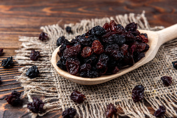 Raisin on dark wooden background.