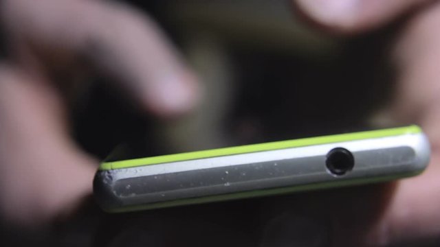Male Fingers Sliding On Touchscreen Surface Of Old Smartphone (Close Up Shot)